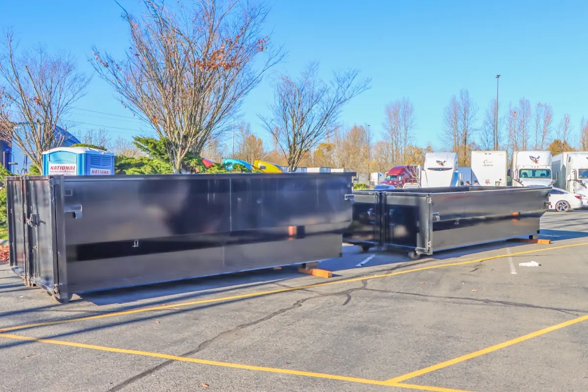 Professional dumpster rental service with roll-off container on residential driveway in Penn